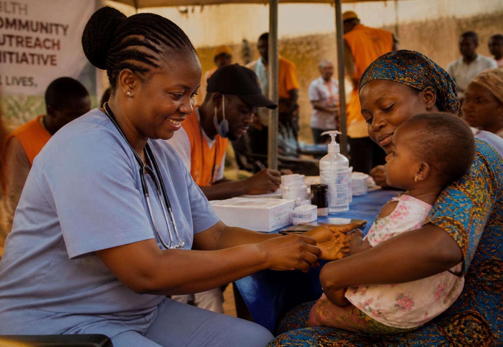 A Chapel Vibes doctor caring for a mother and child at a community health outreach